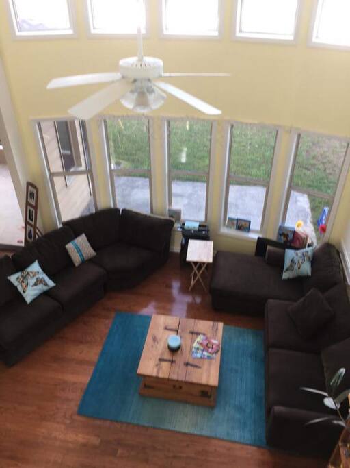 Bright living room space, floor to ceiling windows.