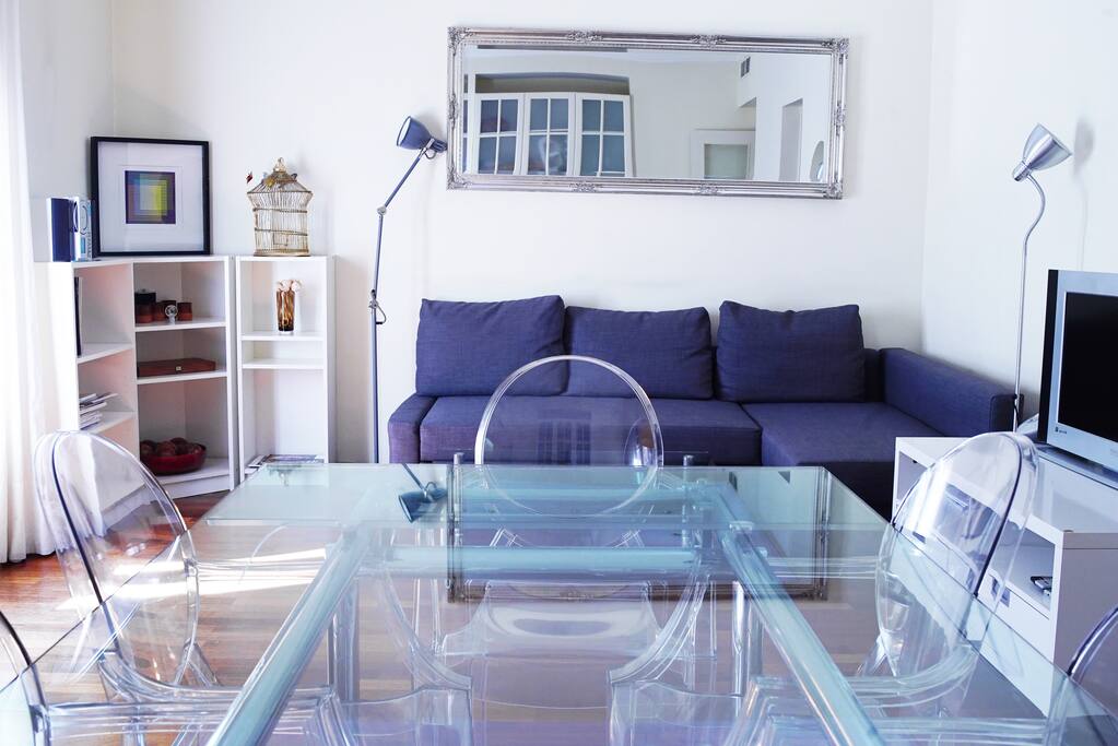 Main living room with TV, dinning table, comfy sofa and two cosy balconies facing a quite street in front of 5* Hotel Fuster