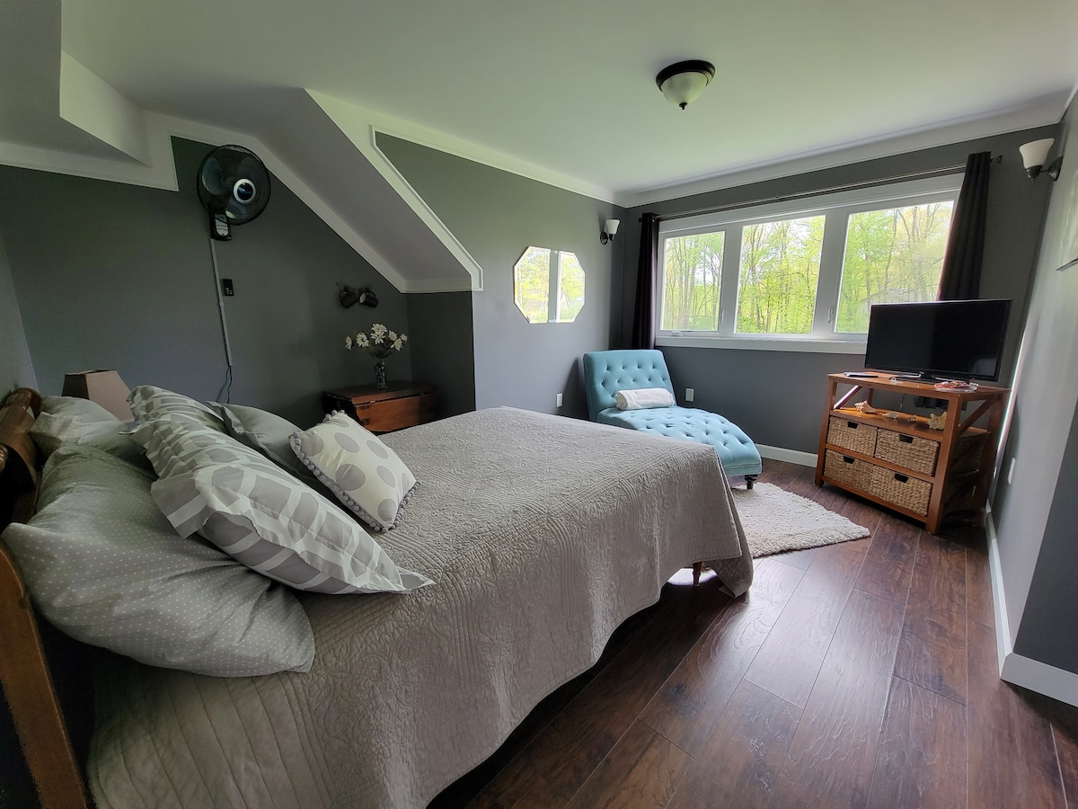 Habitación Meadowview. Cama doble.  Silla cómoda. Con vistas al patio grande, fogata y cancha de voleibol