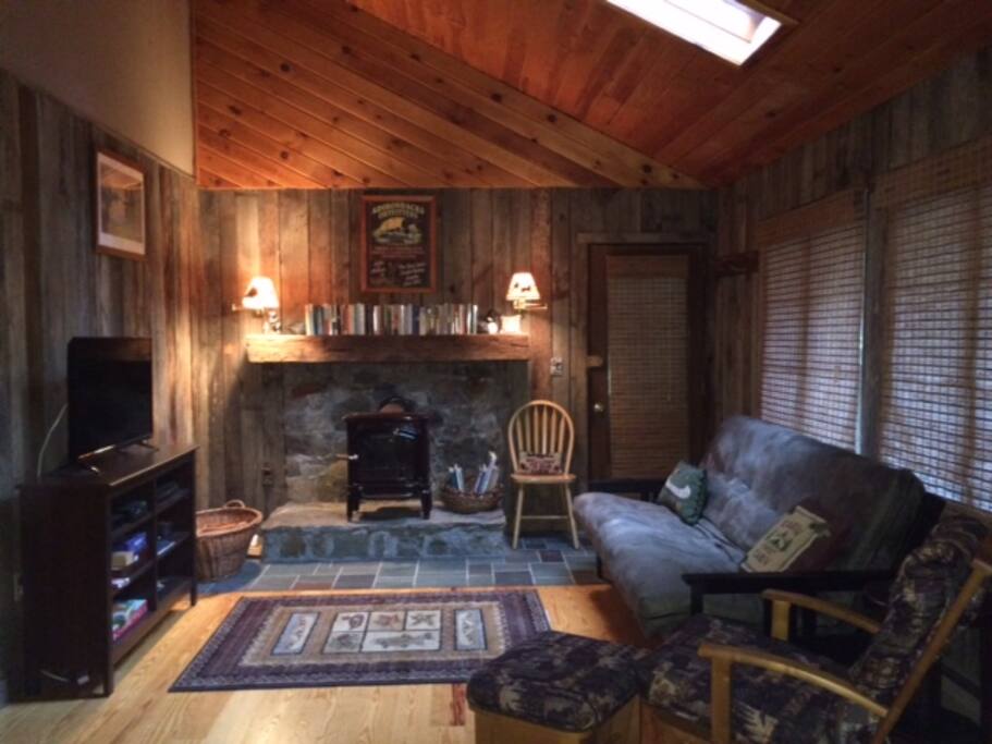 Cozy living room with rustic old barn walls and wood stove