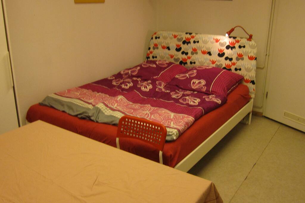 3. Raum mit großem Doppelbett (1,6m x 2m) & weißem Tisch, mit Tischdecke abgedeckt