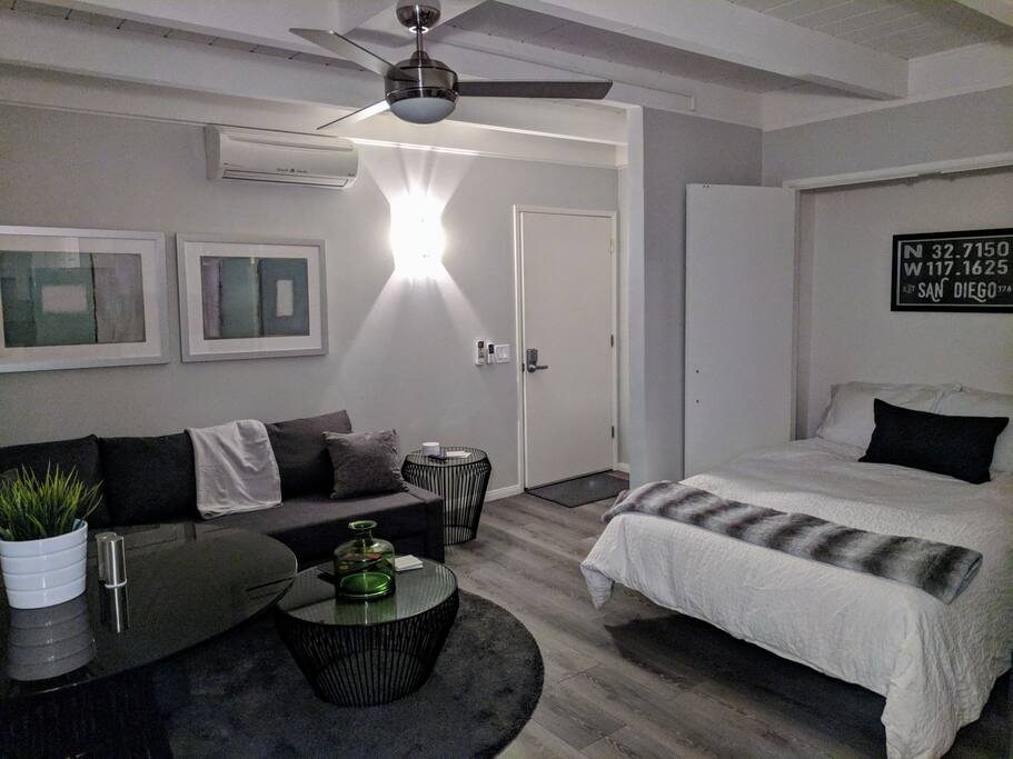 Nighttime view of ultra modern living room and super comfy memory foam mattress bed from kitchen.
