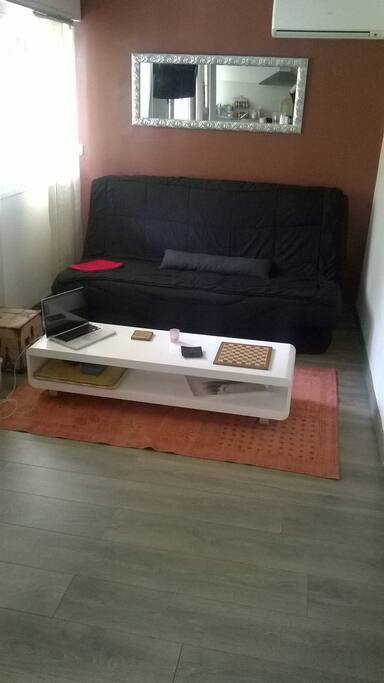 le salon avec tv murale câblée et clic clac confortable