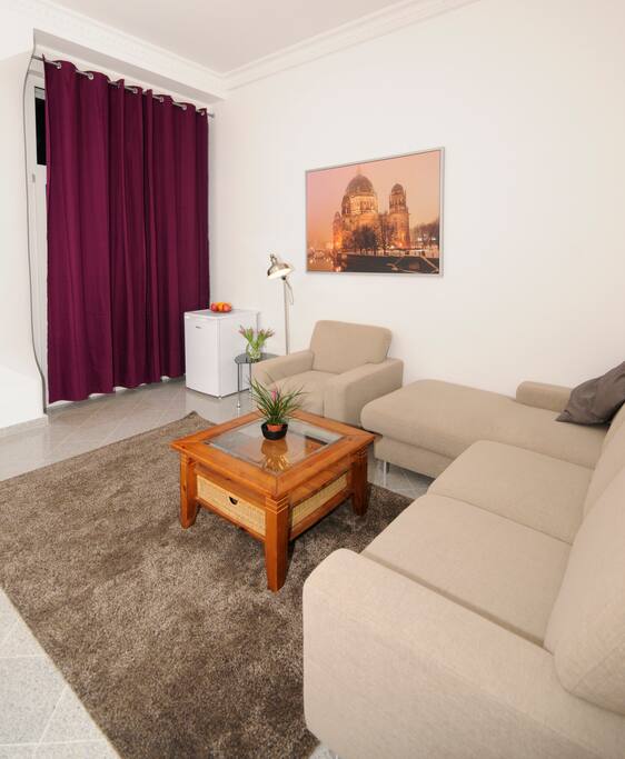large cozy room with double boxspring bed, sofa, fridge, tv, free wifi