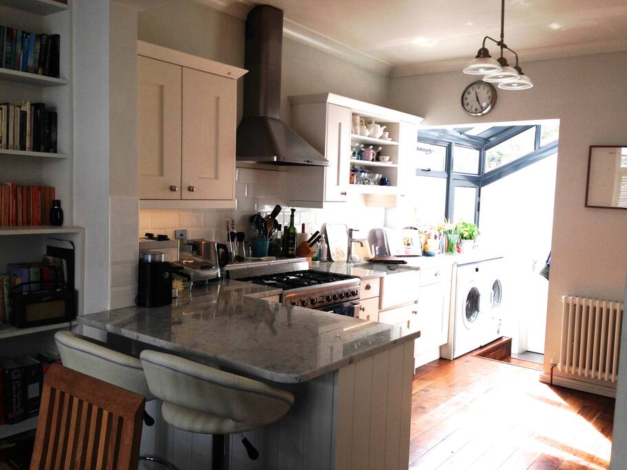 Open-plan, fully equipped kitchen and dining room, with range oven, breakfast bar and 2 bar stools, plus dining table that seats 6; there's also a deep, comfy sofa, well-stocked book shelves and piano. Daylight floods into the side conservatory, which leads to a downstairs toilet.