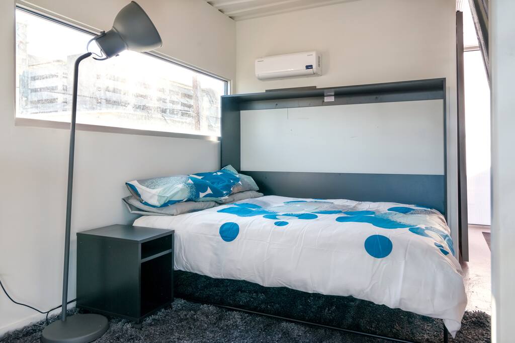 Queen sized murphy bed can be folded up if space is needed when not in use.