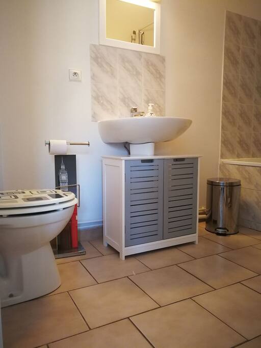La salle de bain avec baignoire
