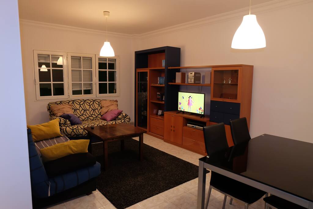 Salón con sofá cama, comedor y Smart TV. Living room with sofa bed, wifi and Smart TV