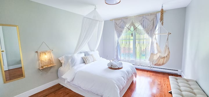 Um dossel de princesa com cortinas tecidas à mão, mesas de cabeceira de macramê e uma cadeira suspensa aconchegante criam um refúgio sonhador e caprichoso.
