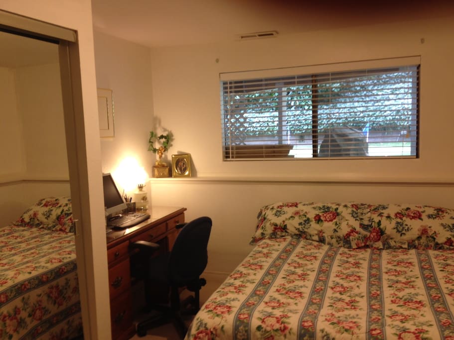 queen size bed, desk, view of putting green and garden