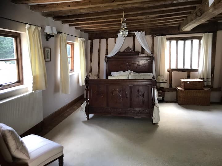 Прекрасниот простор за спиење на Тјудор со 500-годишни греди и антички француски кревет со муселин крошна создава совршен амбиент за романтичен викенд.