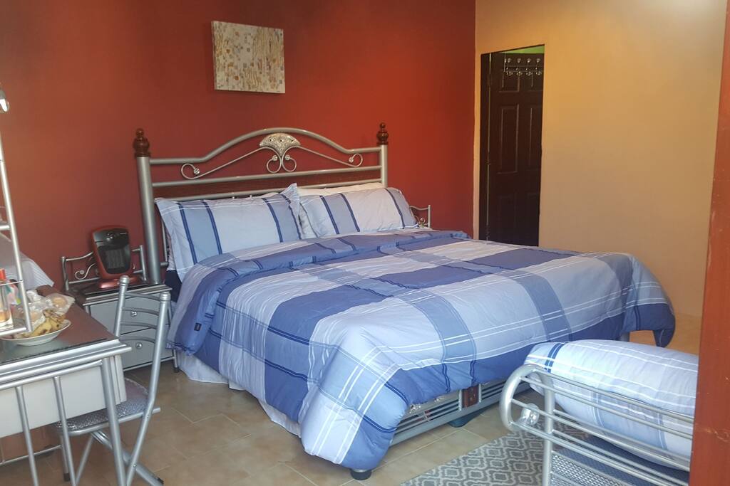 spacious bedroom with everything you need to relax with Air conditioning,LCD TV,heater,iron and ironing board,dresser with chair and a comfy bed and sofa in bedroom for you to enjoy and relax!