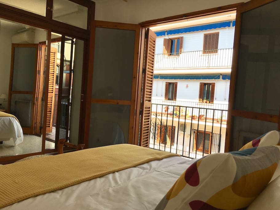 La cama de matrimonio y el armario empotrado con puertas de espejo en el dormitorio.