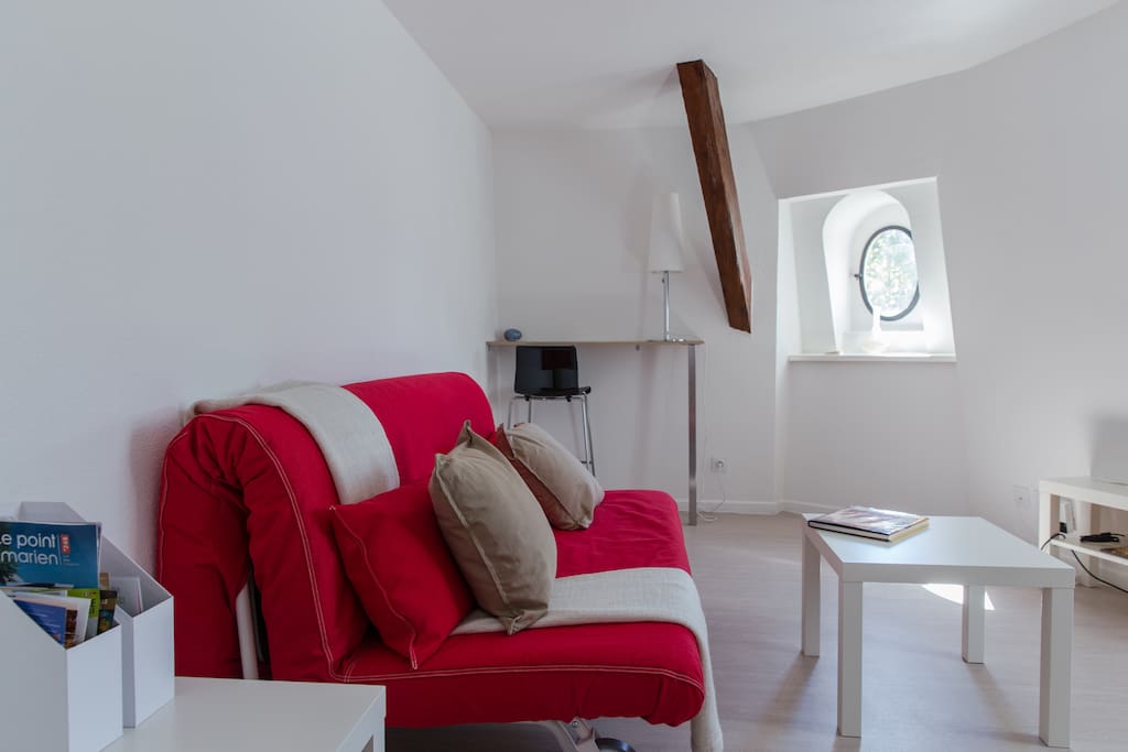 Living room with one king size bed sofa, one single bed sofa, a desk and Television