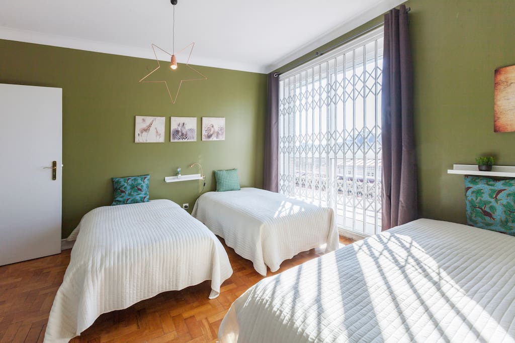 Room Green - 1 double bed and 3 single beds with access to the big balcony an incredible view of the city/ Quarto verde - 1 cama de casal e 3 camas de solteiro com acesso ao terraço com uma vista incrível da cidade