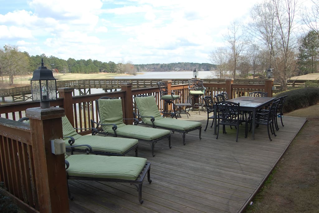 Private deck with table and lounge chairs overlooking the lake.