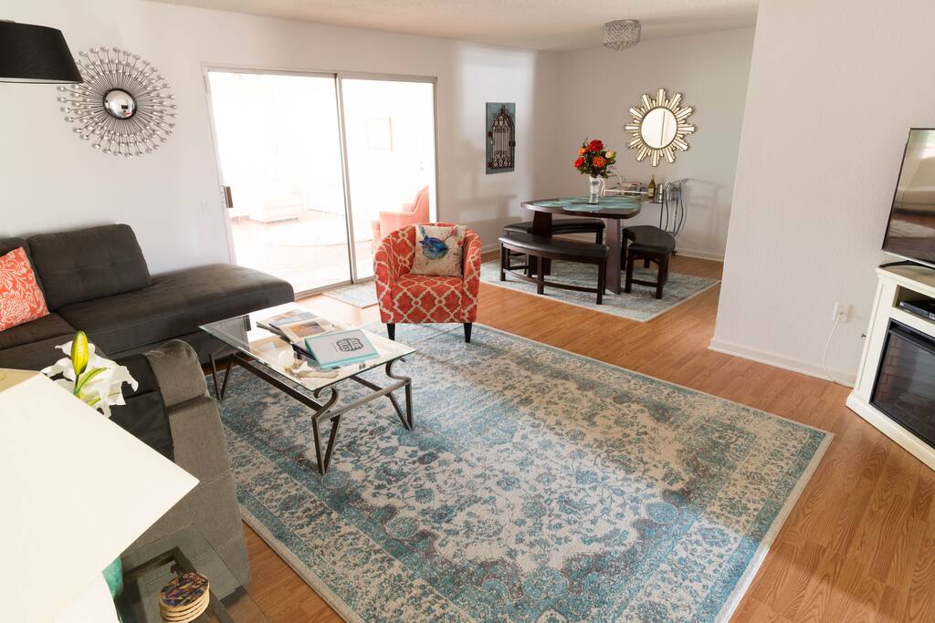 Daytime sun; large TV in living room, and electric fireplace for warmth and ambience.