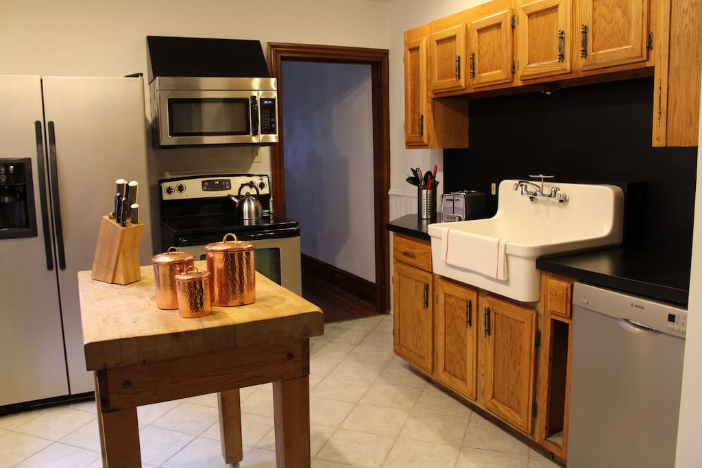Modern kitchen, stainless appliances, butcher block and farmhouse sink.