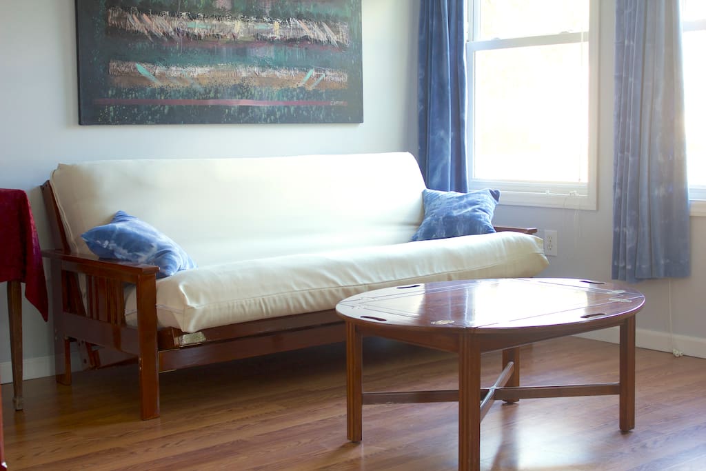 Futon couch lays flat into a second full size bed if needed.