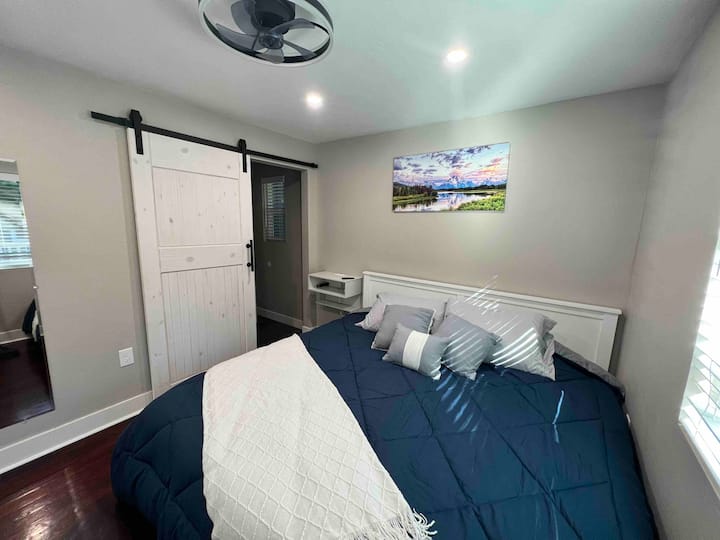 Veliki bračni krevet s kliznim vratima koja vode u kupaonicu, svjetlima koja se mogu prigušiti i ventilatorom iznad glave