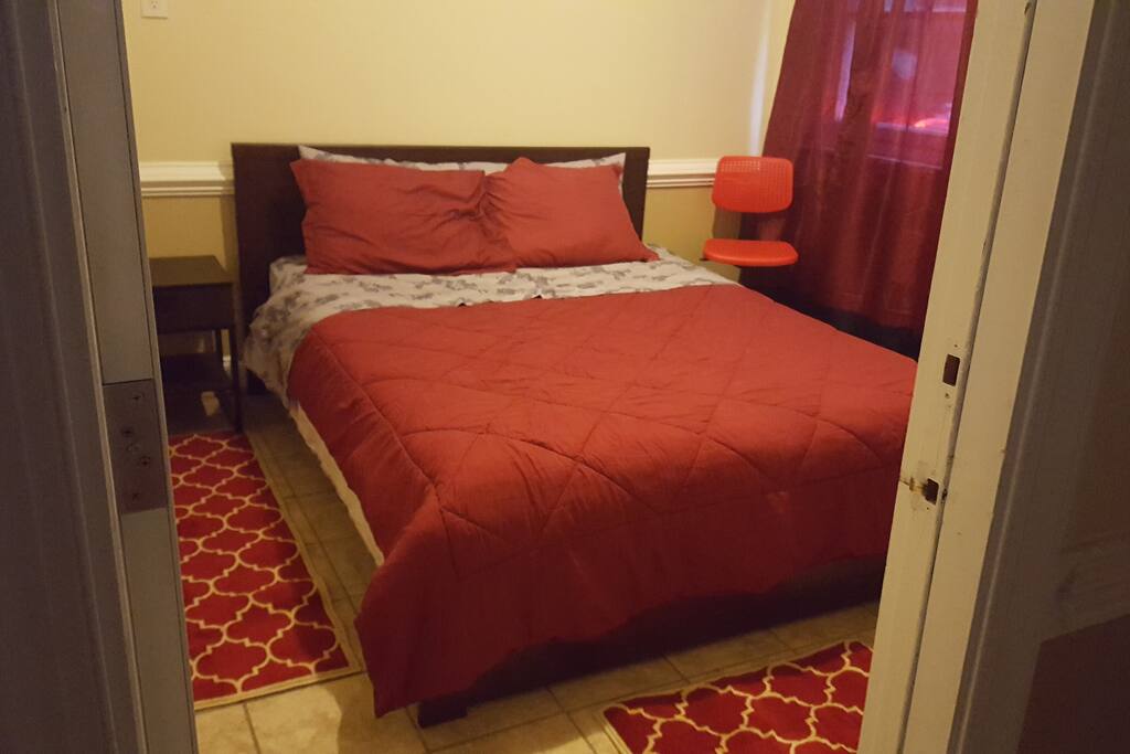 The bedroom has a queen bed and a night stand.