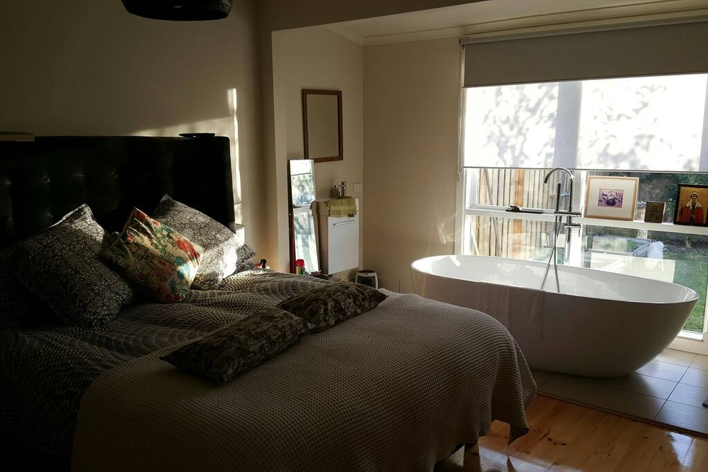 Luxury bedroom with freestanding bath with views over garden