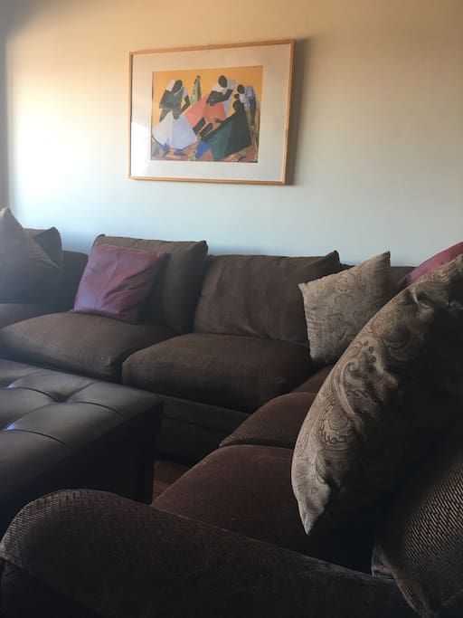 Sectional Sofa and Ottoman in Living Room opposite TV Wall