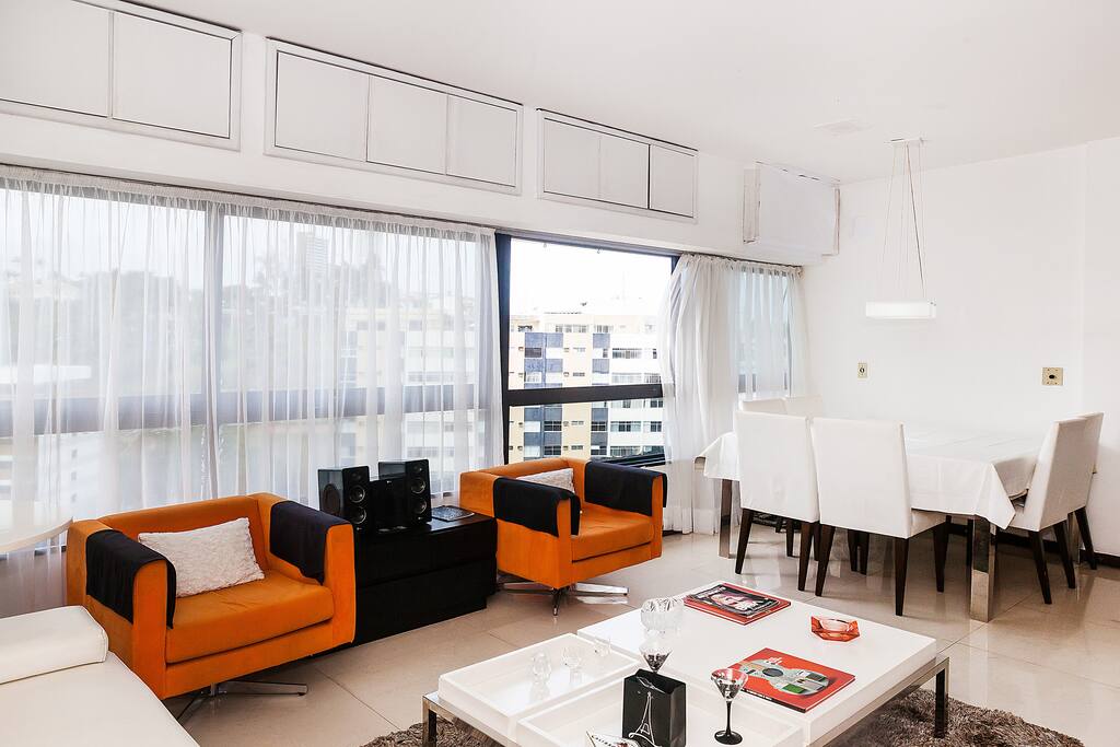 Sala de jantar grande com mesa de 1,50x1,50 m, acomodando seis pessoas.