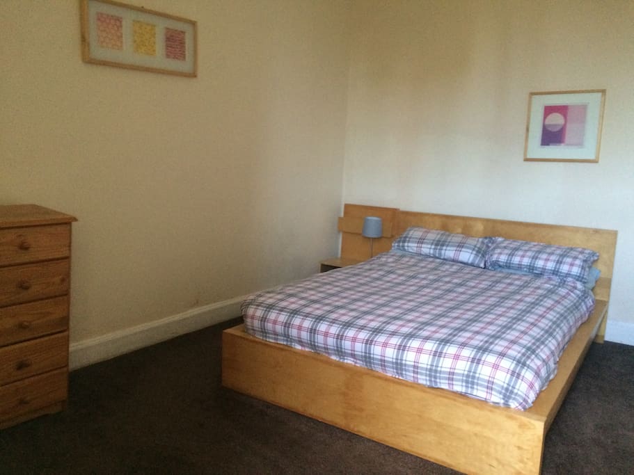 Bedroom with double bed, chest of drawers and wardrobe.