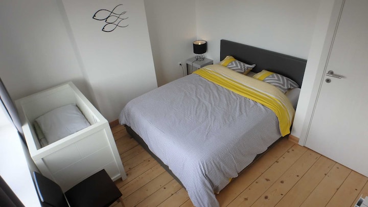 1er étage : Chambre parentale avec lit 160x200 et lit bébé vue au nord sur les terrains de tennis et le parc du minigolf