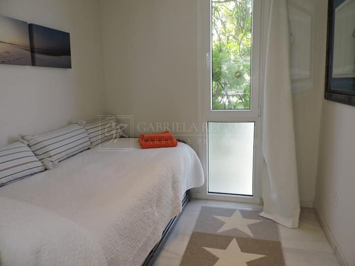 Еднокреветна спална соба со поглед кон градината.