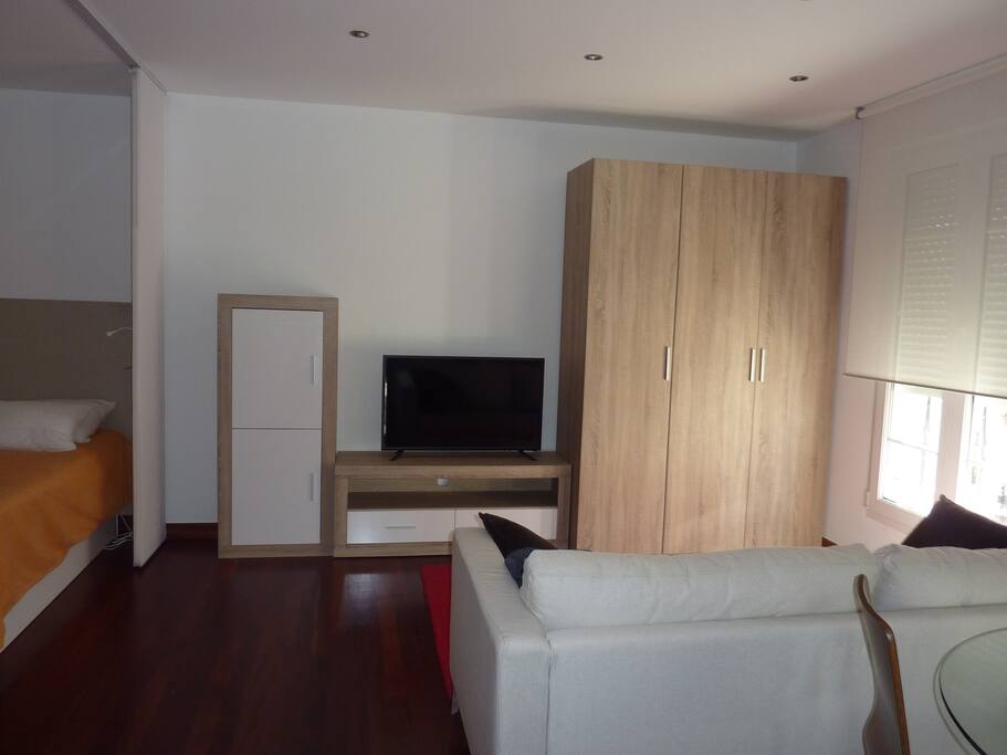 Estudio con cocina y baño independientes amplio sofá y mesa comedor.