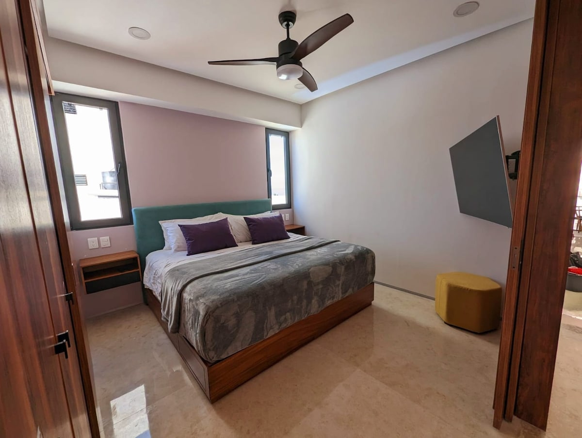 Bedroom 2, with a king size bed,  AC, 55inch smart TV, and an ensuite bathroom.