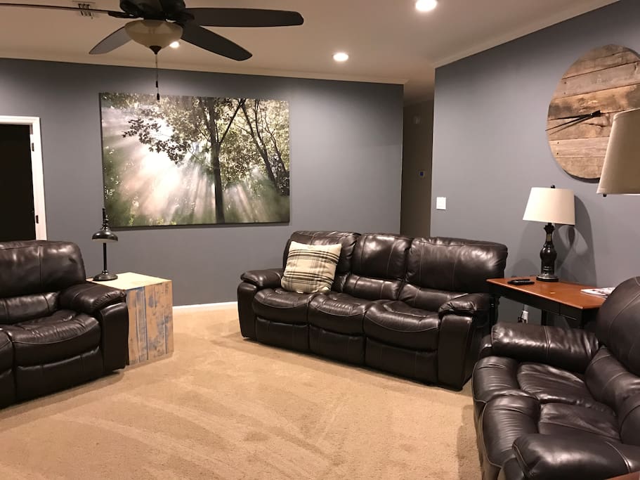 Open living room with reclining couches and new 65" tv