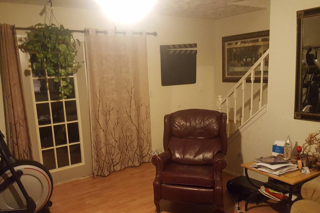 The recliner, windows, and stairs leading to the second floor