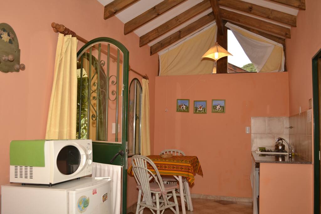 Sector de cocina y comedor con Heladera, microondas y anafe