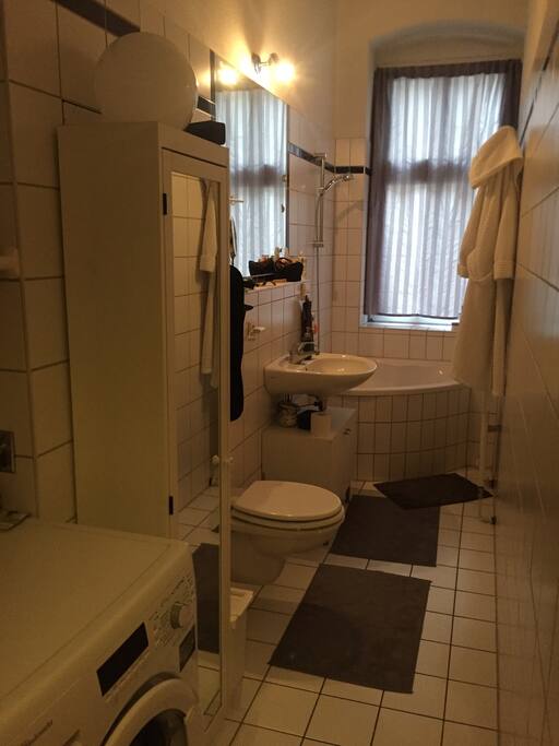 Badezimmer mit Eckbadewanne, Waschmaschine, großer Spiegel