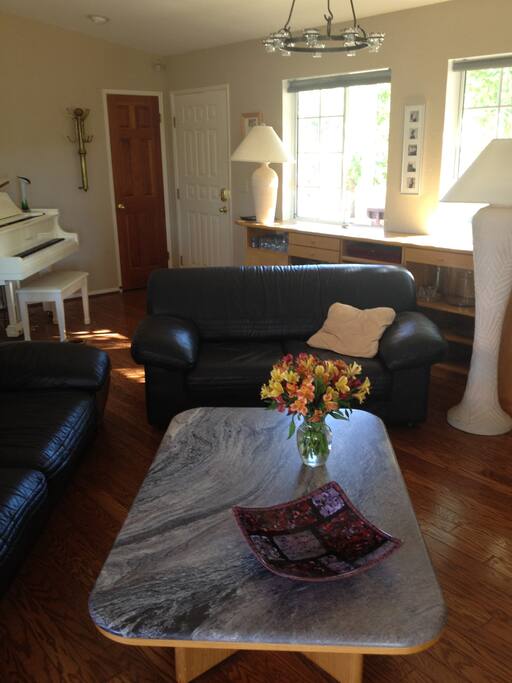 Living room area with Baby Grand piano in the background.