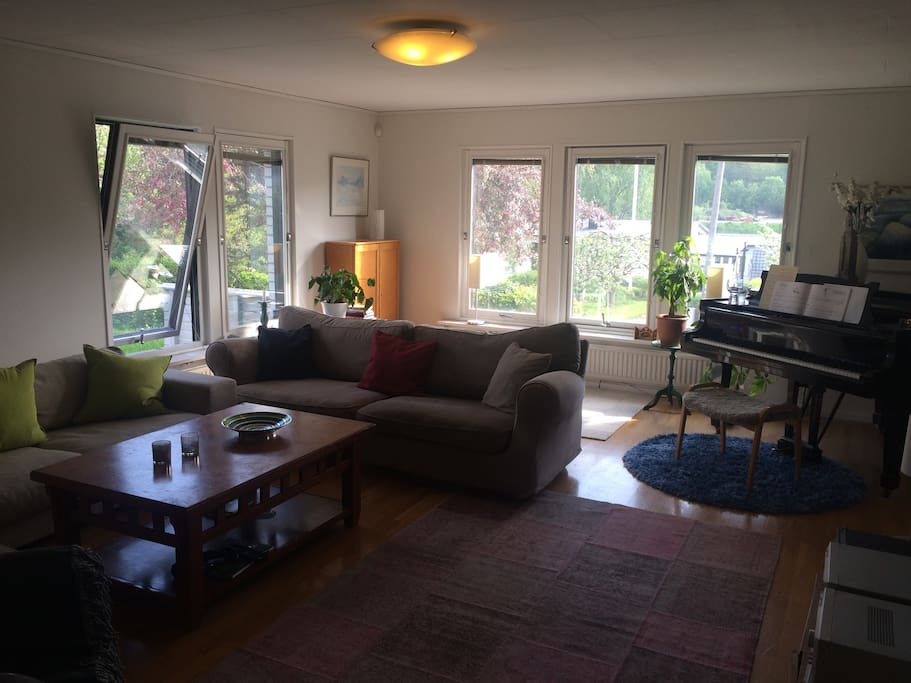 Spacious living room with two large coaches, piano and television.