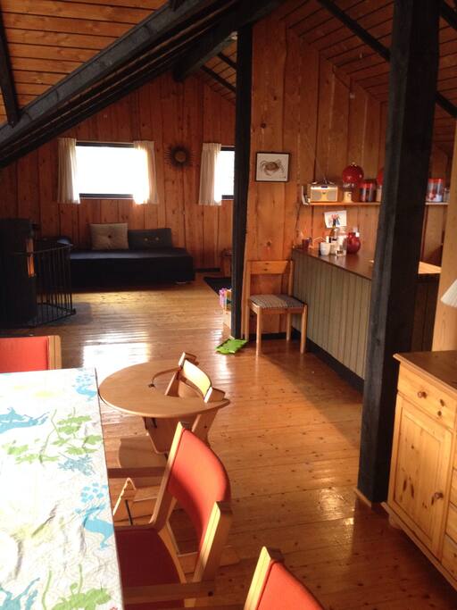 Front left, dining table; to the right, kitchen; at the back, living room