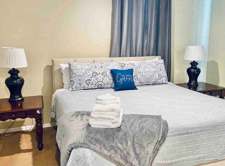 Голяма главна спалня с двойно легло, 2 нощни шкафчета, телевизор с приложения Roku, завеси за затъмняване и достатъчно място за гардероб и рафтове. Води до основна баня, където се намират и пералните удобства (пералня/сушилня)