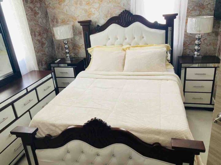 Bienvenido a nuestro dormitorio clásico y tradicional  totalmente amueblado con panel tapizado con mechones. Diseño tradicional con miel y toque cómodo. Vestidor y espejo disponibles con lámparas dobles y mesitas de noche.