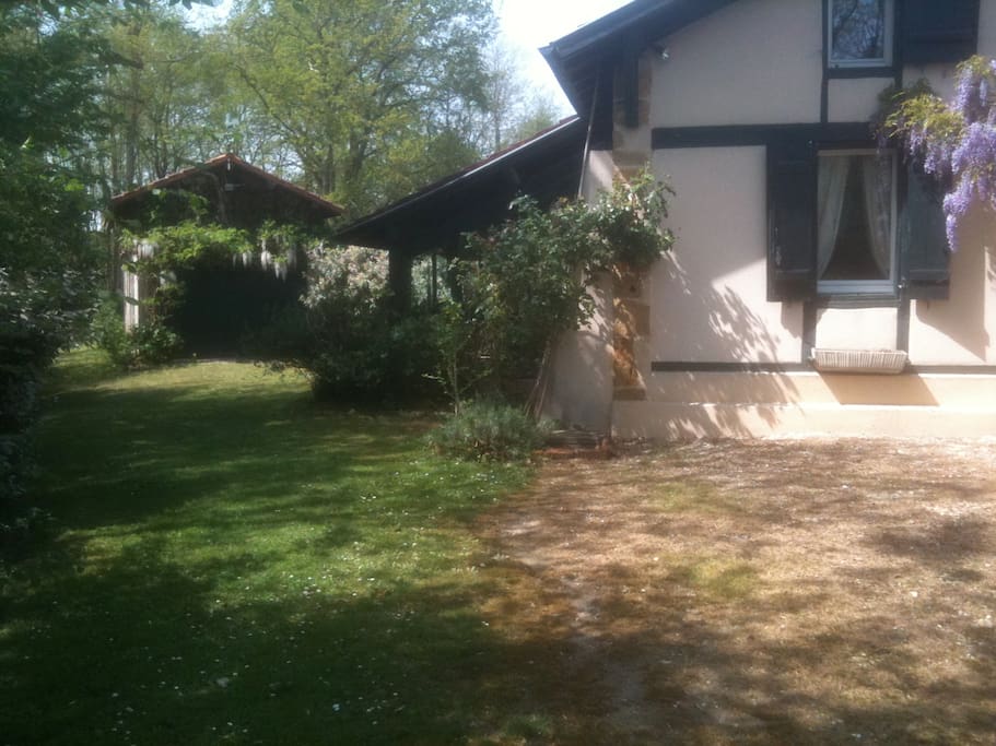 Côté de la maison avec la véranda et la grange