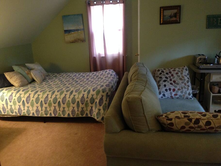 Living area showing couch and queen bed.