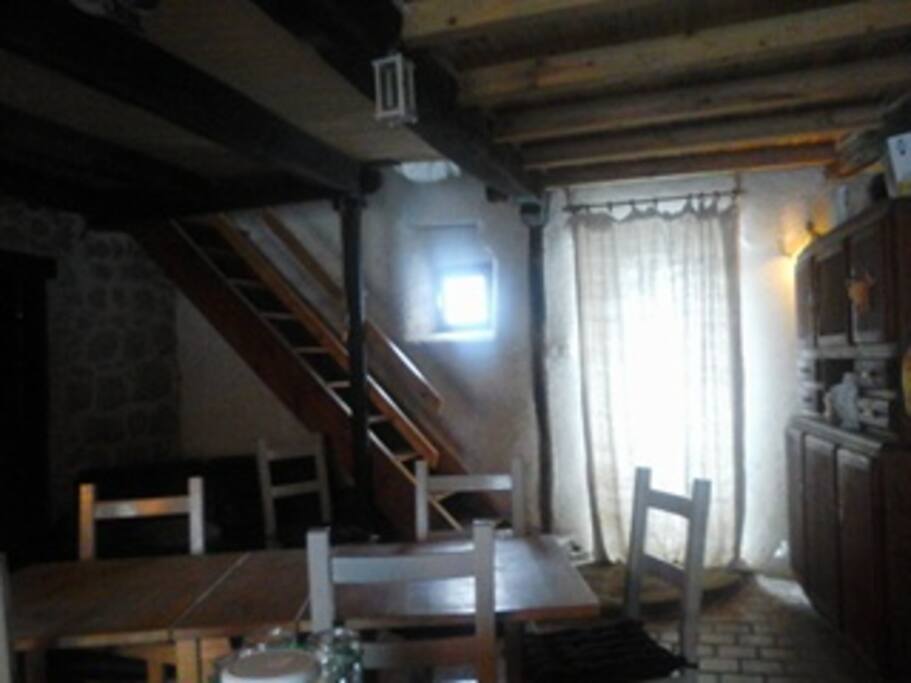 table pour six, porte avant et arrière, donnant sur le puits (sécurisé), escalier 1 menant à une grande chambre séparé avec un coin enfant par des rideaux et dressing, et une chambre plus petite (14 m2) avec bureau et armoire, lit simple et porte. A gauche la porte menant à la salle de bain