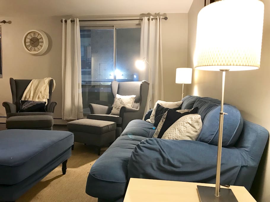 Spacious living room, full couch, two chairs and ottomans, matching "coffee table", desk, lamps, end tables, fluffy pillows and a cozy blanket!