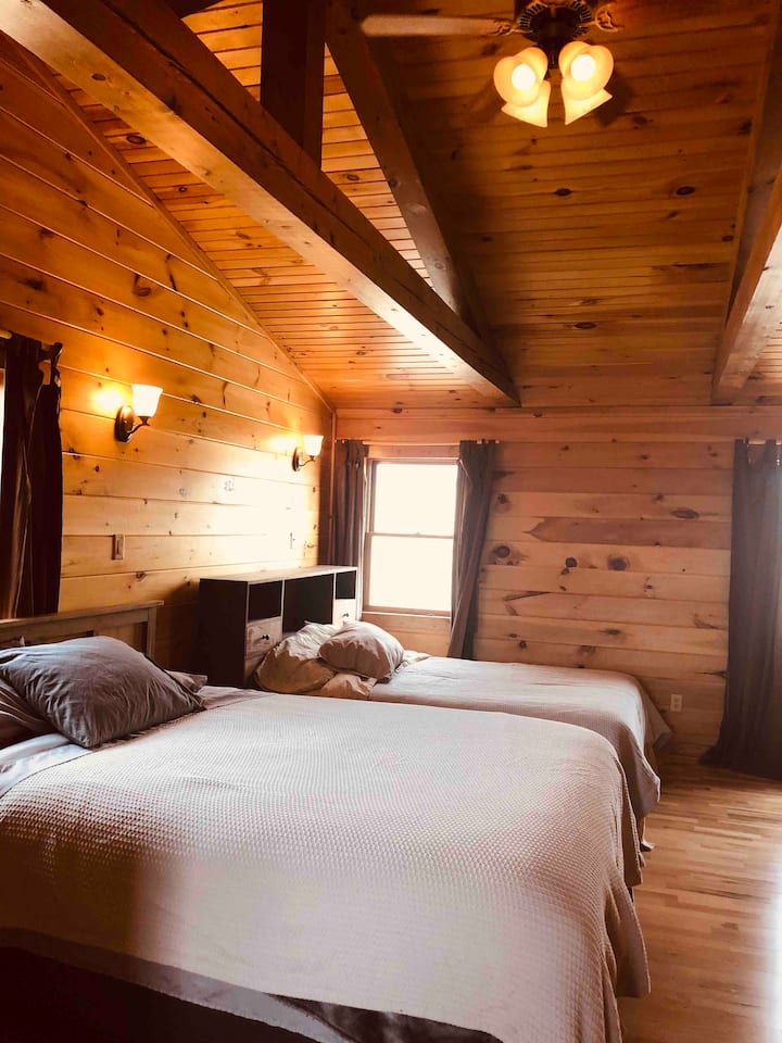 Amplio dormitorio en la planta superior con una cama queen y una cama doble.