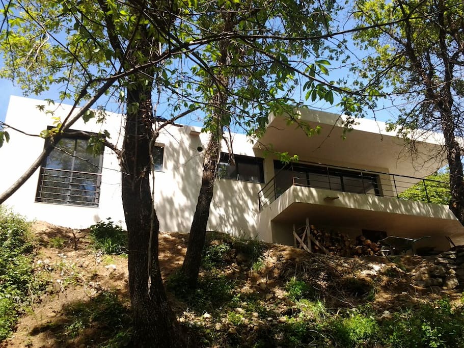 Façade de la maison, coté chambre et terrasse avec coin repas, vu du ruisseau.