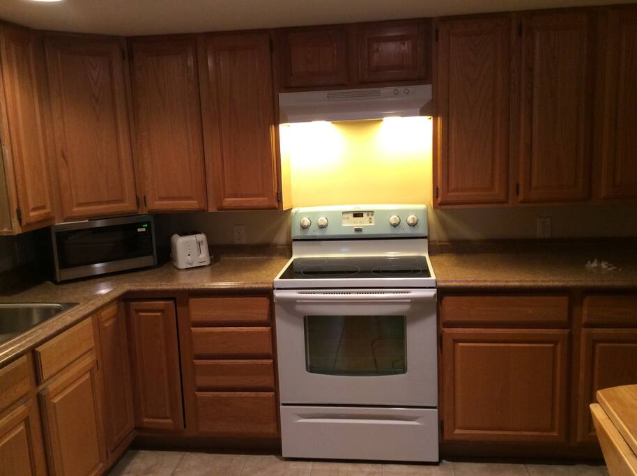 Full size kitchen including dishwasher, dishes, appliances.