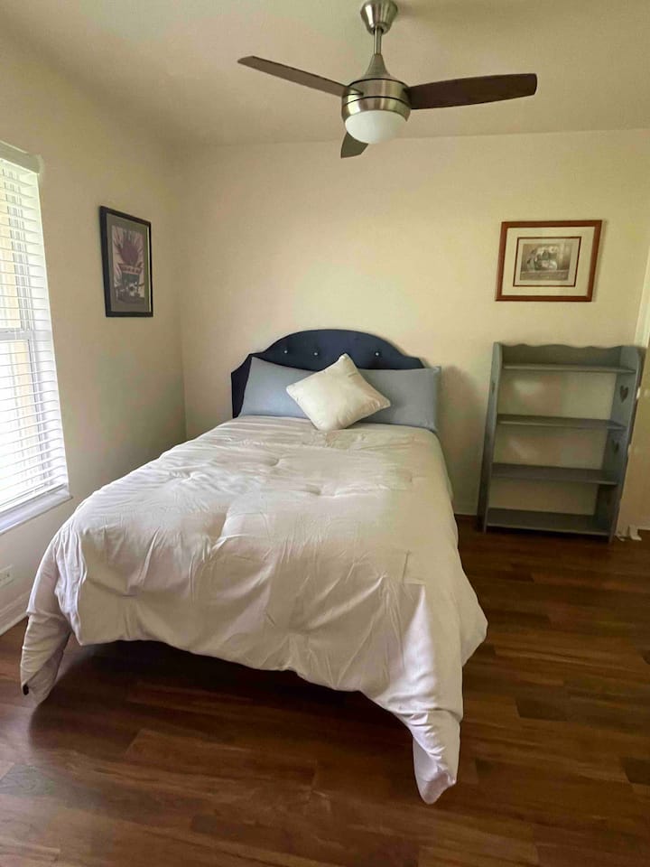 חדר שינה שלישי עם מיטה בגודל מלא, ארון ומאוורר.